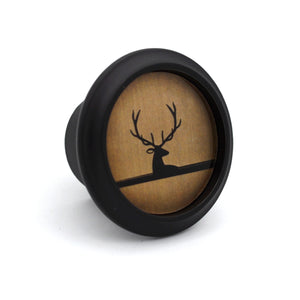 Decorative knob with a deer silhouette on a wooden background